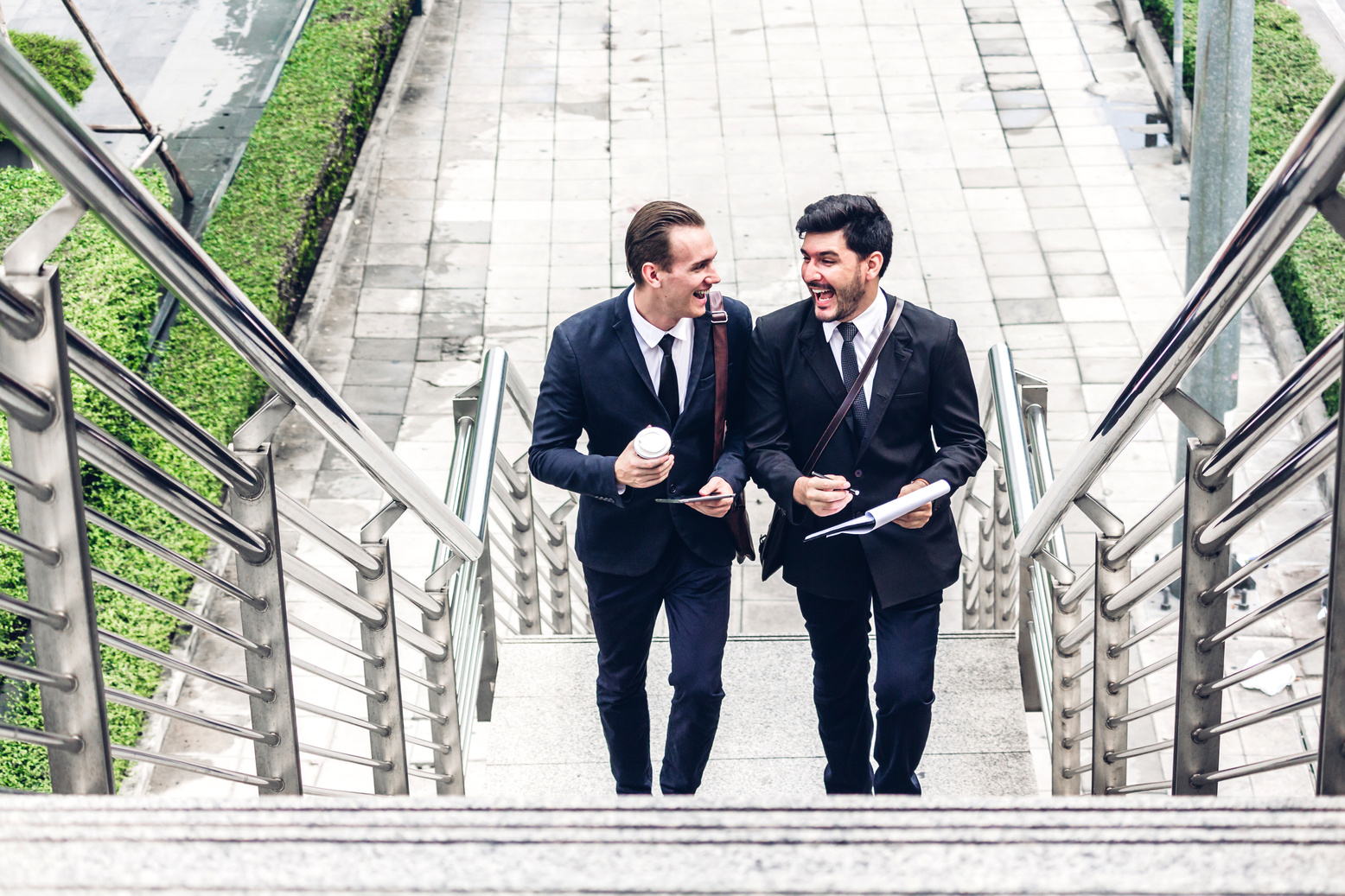 Two Smiling Businessmen Talking and Walking in the City